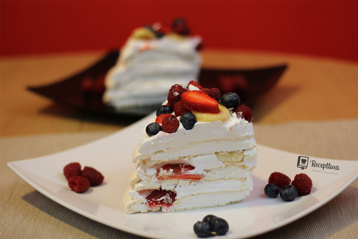Poslužena sniježnobijela Pavlova torta sa raznim voćem izgleda neodoljivo.